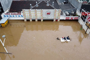 <p>Foto aerial warga melintas dengan perahu karet melintasi banjir di kawasan Kemang, Jakarta Selatan, Sabtu, 20 Februari 2021. Foto : Panji Asmoro/TrenAsia</p>