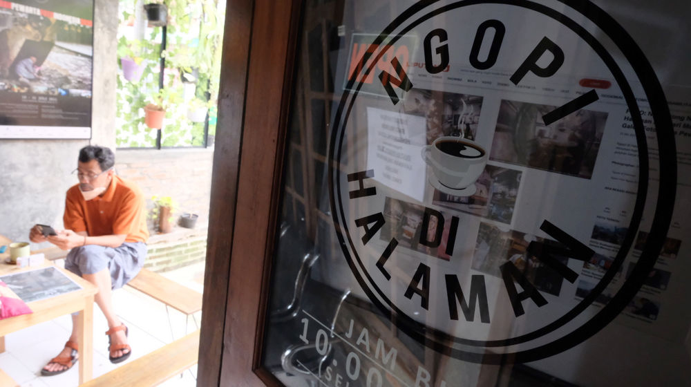 <p>Pemilik kedai, Eko S Hilam (kiri) menemani pengunjung di kedai kopi “Ngopi di Halaman” di Jalan Pulo Kamboja, Kebayoran Lama, Jakarta, Kamis, 25 Februari 2021. Foto: Ismail Pohan/TrenAsia</p>