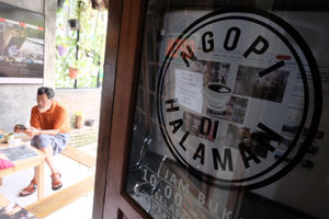 <p>Pemilik kedai, Eko S Hilam (kiri) menemani pengunjung di kedai kopi “Ngopi di Halaman” di Jalan Pulo Kamboja, Kebayoran Lama, Jakarta, Kamis, 25 Februari 2021. Foto: Ismail Pohan/TrenAsia</p>