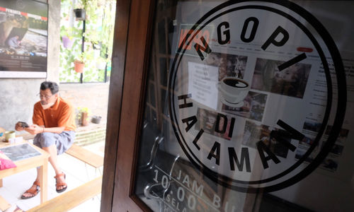<p>Pemilik kedai, Eko S Hilam (kiri) menemani pengunjung di kedai kopi “Ngopi di Halaman” di Jalan Pulo Kamboja, Kebayoran Lama, Jakarta, Kamis, 25 Februari 2021. Foto: Ismail Pohan/TrenAsia</p>
