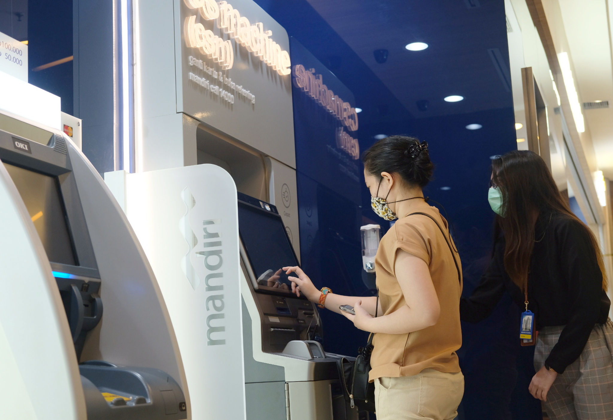 <p>Petugas edukator mendampingi nasabah mengganti kartu debit ATM yang baru menggunakan Customer Service Machine (CSM) di kantor cabang Bank Mandiri Edu-Branch, Pondok Indah Mall 1, Jakarta, Kamis, 18 Februari 2021. Foto: Ismail Pohan/TrenAsia</p>
