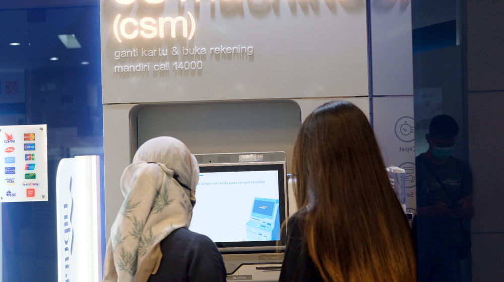 <p>Petugas edukator mendampingi nasabah mengganti kartu debit ATM dengan chip menggunakan Customer Service Machine (CSM) di kantor cabang Bank Mandiri Edu-Branch, Pondok Indah Mall 1, Jakarta, Kamis, 18 Februari 2021. Foto: Ismail Pohan/TrenAsia</p>

