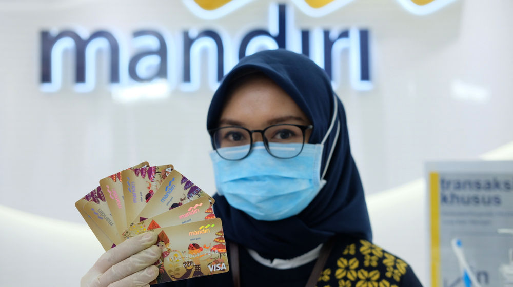 <p>Karyawati menunjukkan kartu debit ATM dengan chip di kantor cabang Bank Mandiri Edu-Branch, Pondok Indah Mall 1, Jakarta, Kamis, 18 Februari 2021. Foto: Ismail Pohan/TrenAsia</p>
