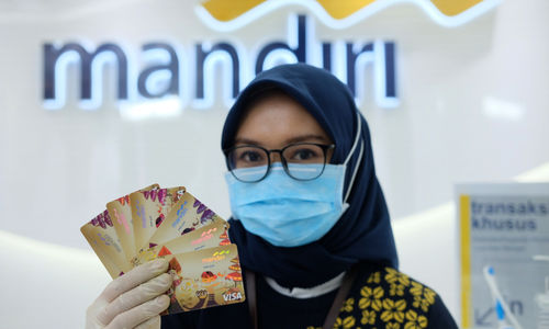 <p>Karyawati menunjukkan kartu debit ATM dengan chip di kantor cabang Bank Mandiri Edu-Branch, Pondok Indah Mall 1, Jakarta, Kamis, 18 Februari 2021. Foto: Ismail Pohan/TrenAsia</p>
