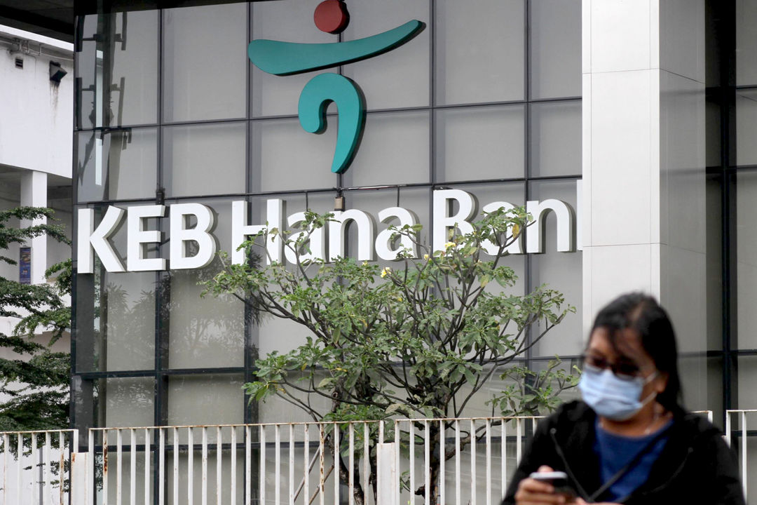 <p>Warga melintas dengan latar belakang logo di gedung KEB Hana Bank, di Jalan Gatot Subroto, Jakarta, Selasa, 16 Februari 2021. Foto: Panji Asmoro/TrenAsia</p>
