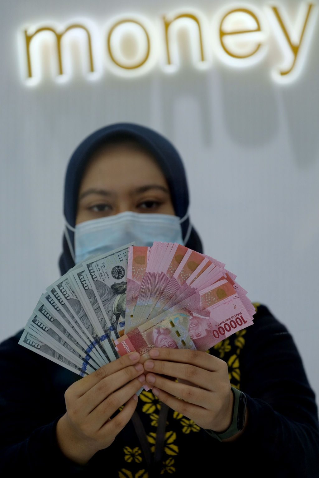 <p>Karyawati menunjukan mata uang Rupiah dan Dolar AS di Jakarta, Kamis, 18 Februari 2021. Foto: Ismail Pohan/TrenAsia</p>
