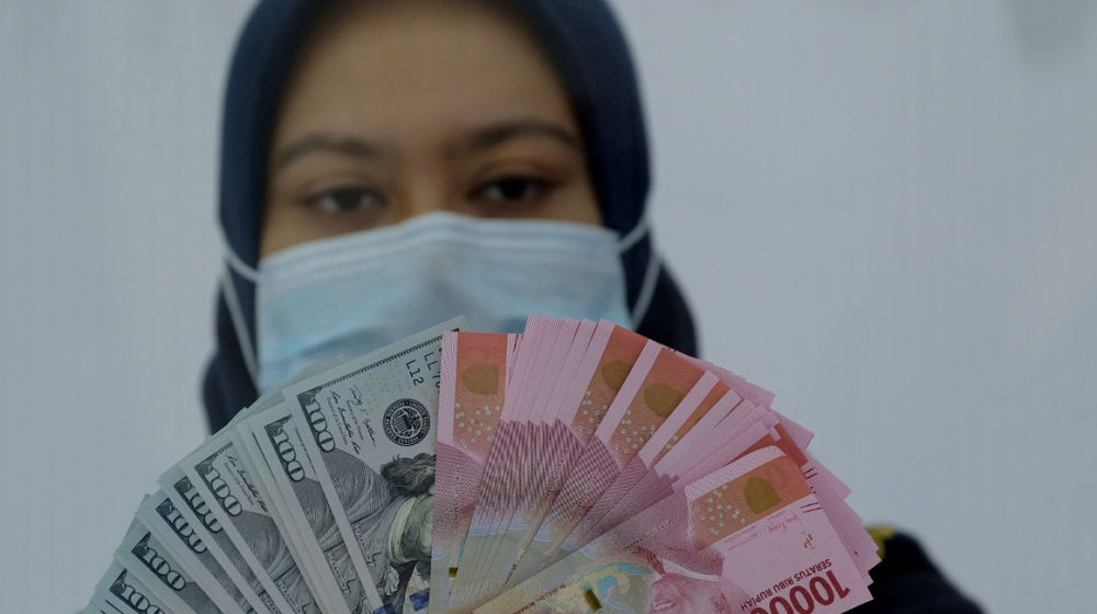 <p>Karyawati menunjukan mata uang Rupiah dan Dolar AS di Jakarta, Kamis, 18 Februari 2021. Foto: Ismail Pohan/TrenAsia</p>
