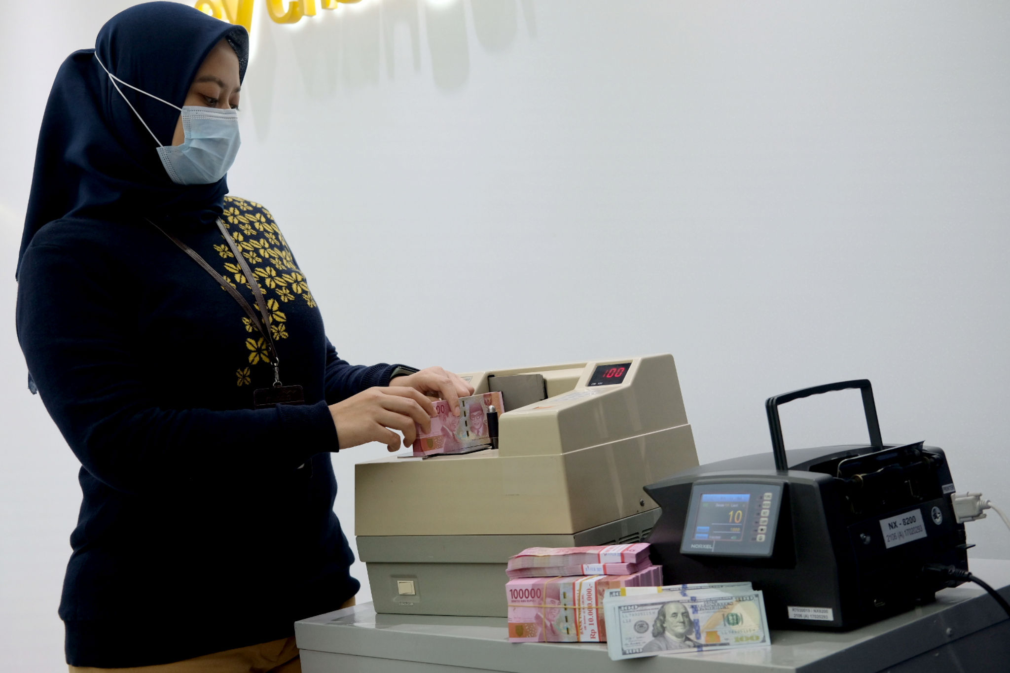 <p>Karyawati menghitung mata uang Rupiah di Jakarta, Kamis, 18 Februari 2021. Foto: Ismail Pohan/TrenAsia</p>
