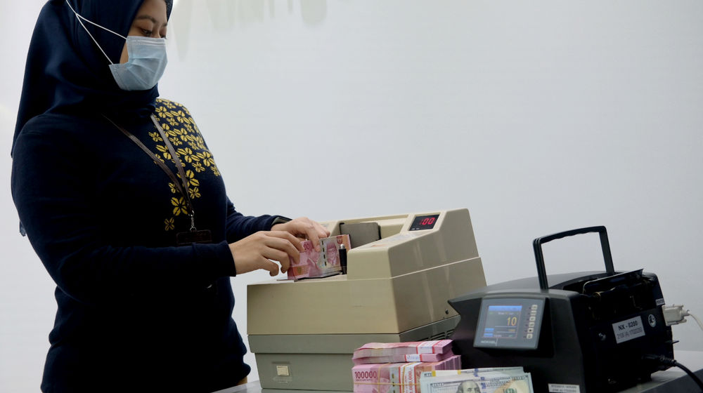 <p>Karyawati menghitung mata uang Rupiah di Jakarta, Kamis, 18 Februari 2021. Foto: Ismail Pohan/TrenAsia</p>
