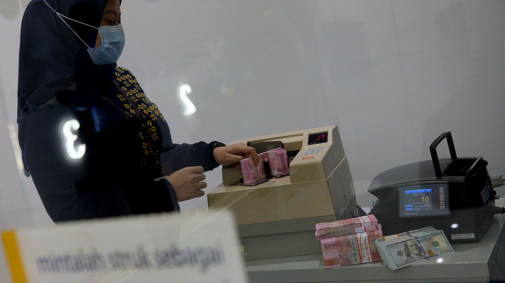 <p>Karyawati menghitung mata uang Rupiah di Jakarta, Kamis, 18 Februari 2021. Foto: Ismail Pohan/TrenAsia</p>