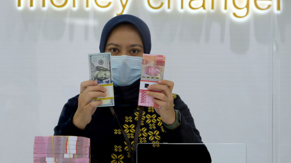 <p>Karyawati menunjukan mata uang Rupiah dan Dolar AS di Jakarta, Kamis, 18 Februari 2021. Foto: Ismail Pohan/TrenAsia</p>

