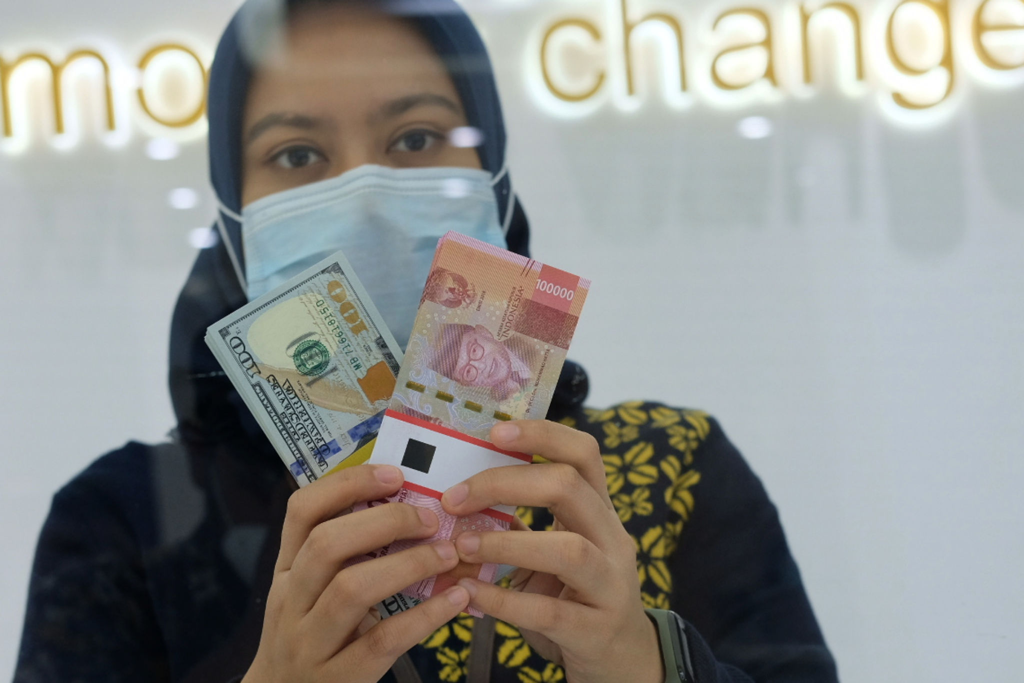 <p>Karyawati menunjukan mata uang Rupiah dan Dolar AS di Jakarta, Kamis, 18 Februari 2021. Foto: Ismail Pohan/TrenAsia</p>

