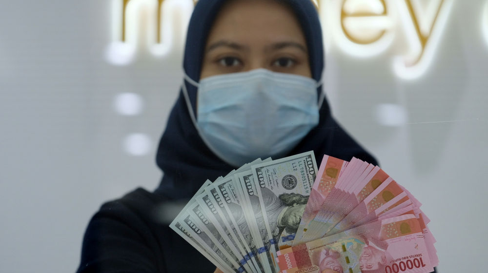 <p>Karyawati menunjukan mata uang Rupiah dan Dolar AS di Jakarta, Kamis, 18 Februari 2021. Foto: Ismail Pohan/TrenAsia</p>