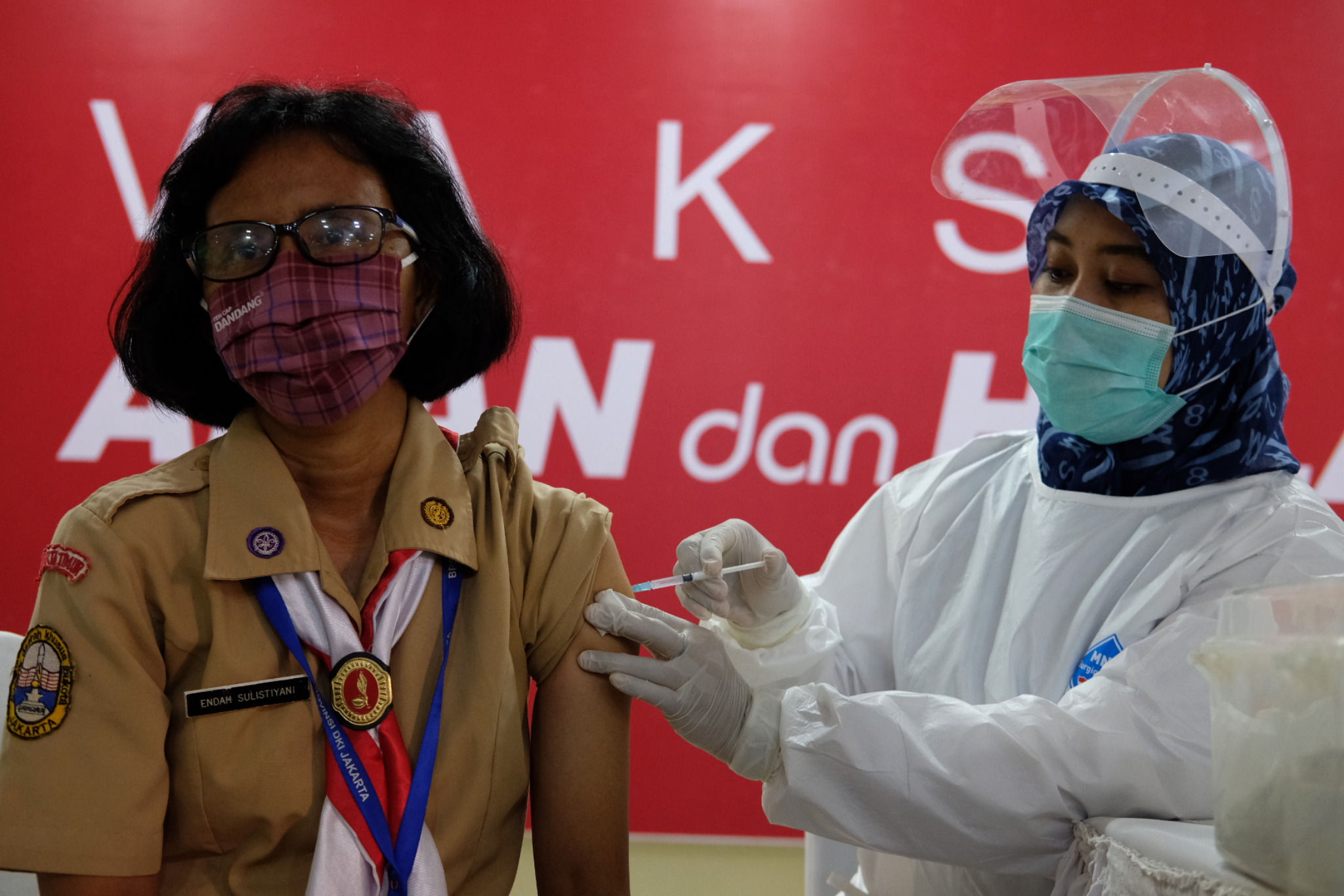 <p>Petugas menyuntikkan vaksin kepada tenaga pendidikan saat vaksinasi tahap II untuk tenaga pendidik, guru, dan dosen di SMA Negeri 70 Jakarta, Rabu, 24 Februari 2021. Foto: Ismail Pohan/TrenAsia</p>
