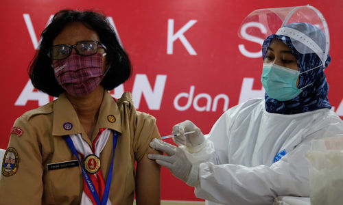 <p>Petugas menyuntikkan vaksin kepada tenaga pendidikan saat vaksinasi tahap II untuk tenaga pendidik, guru, dan dosen di SMA Negeri 70 Jakarta, Rabu, 24 Februari 2021. Foto: Ismail Pohan/TrenAsia</p>
