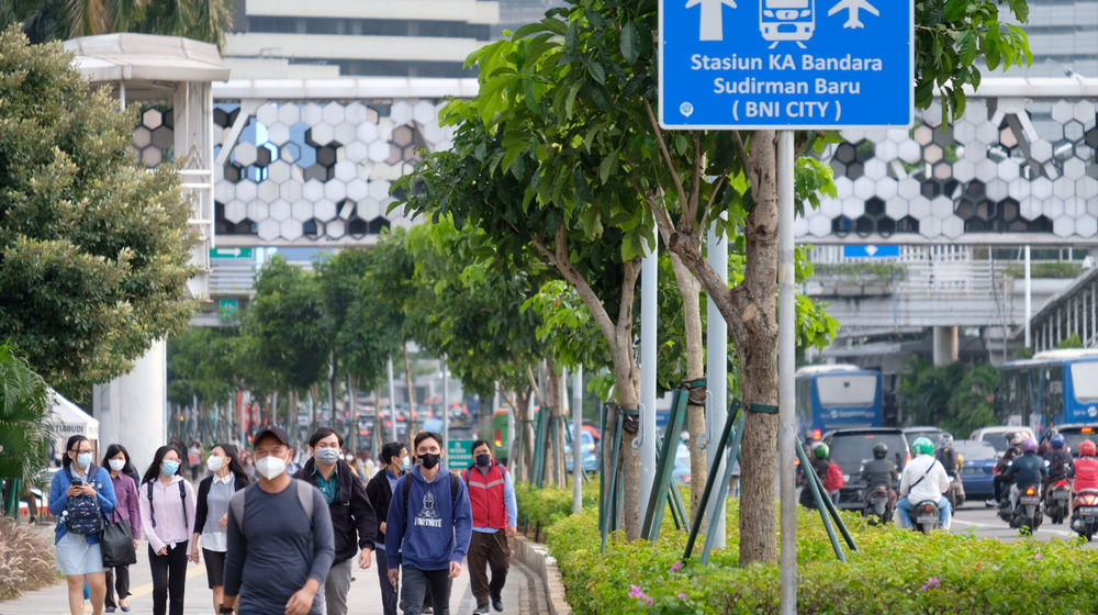 <p>Pekerja melintas pada jam pulang kerja di kawasan Jalan Jenderal Sudirman, Jakarta, Senin, 22 Februari 2021. Foto: Ismail Pohan/TrenAsia</p>
