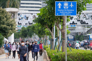 <p>Pekerja melintas pada jam pulang kerja di kawasan Jalan Jenderal Sudirman, Jakarta, Senin, 22 Februari 2021. Foto: Ismail Pohan/TrenAsia</p>
