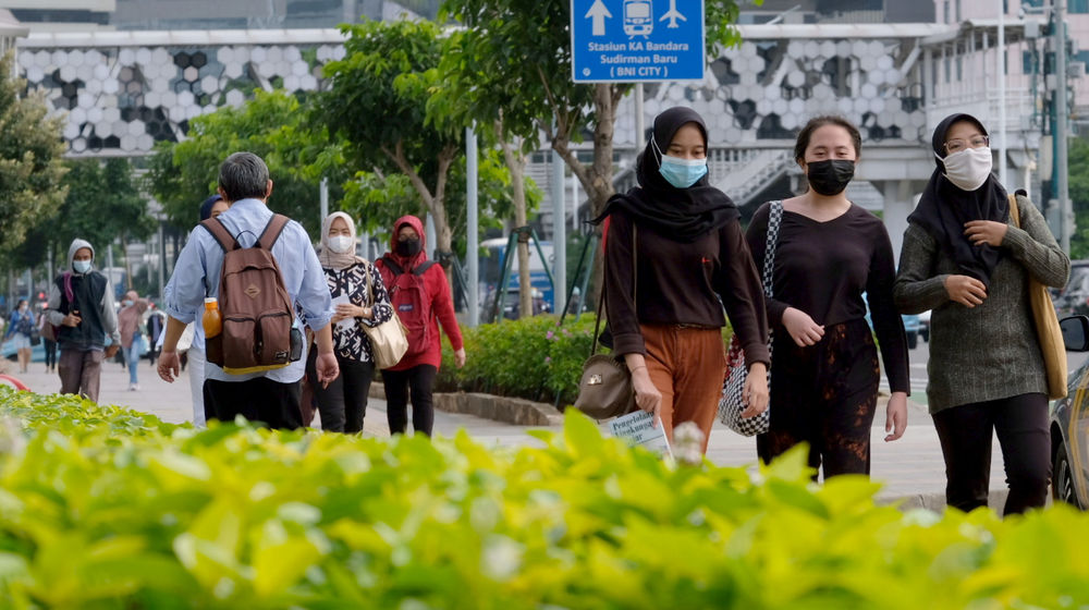 <p>Pekerja melintas pada jam pulang kerja di kawasan Jalan Jenderal Sudirman, Jakarta, Senin, 22 Februari 2021. Foto: Ismail Pohan/TrenAsia</p>
