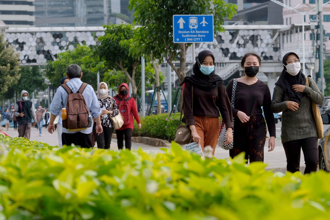 <p>Pekerja melintas pada jam pulang kerja di kawasan Jalan Jenderal Sudirman, Jakarta, Senin, 22 Februari 2021. Foto: Ismail Pohan/TrenAsia</p>
