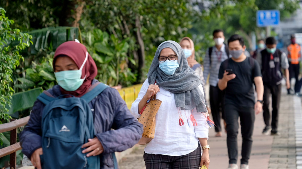 <p>Pekerja melintas pada jam pulang kerja di kawasan Jalan Jenderal Sudirman, Jakarta, Senin, 22 Februari 2021. Foto: Ismail Pohan/TrenAsia</p>
