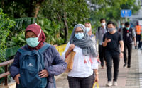 <p>Pekerja melintas pada jam pulang kerja di kawasan Jalan Jenderal Sudirman, Jakarta, Senin, 22 Februari 2021. Foto: Ismail Pohan/TrenAsia</p>
