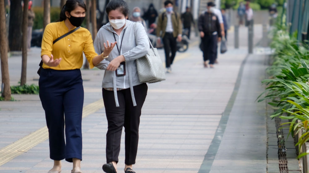 <p>Pekerja melintas pada jam pulang kerja di kawasan Jalan Jenderal Sudirman, Jakarta, Senin, 22 Februari 2021. Foto: Ismail Pohan/TrenAsia</p>
