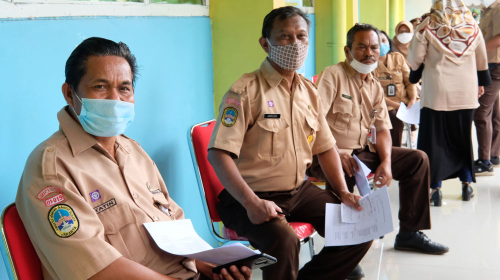 <p>Sejumlah guru mengantre saat pemberian vaksinasi tahap II untuk tenaga pendidik, guru, dan dosen di SMA Negeri 70 Jakarta, Rabu, 24 Februari 2021. Foto: Ismail Pohan/TrenAsia</p>
