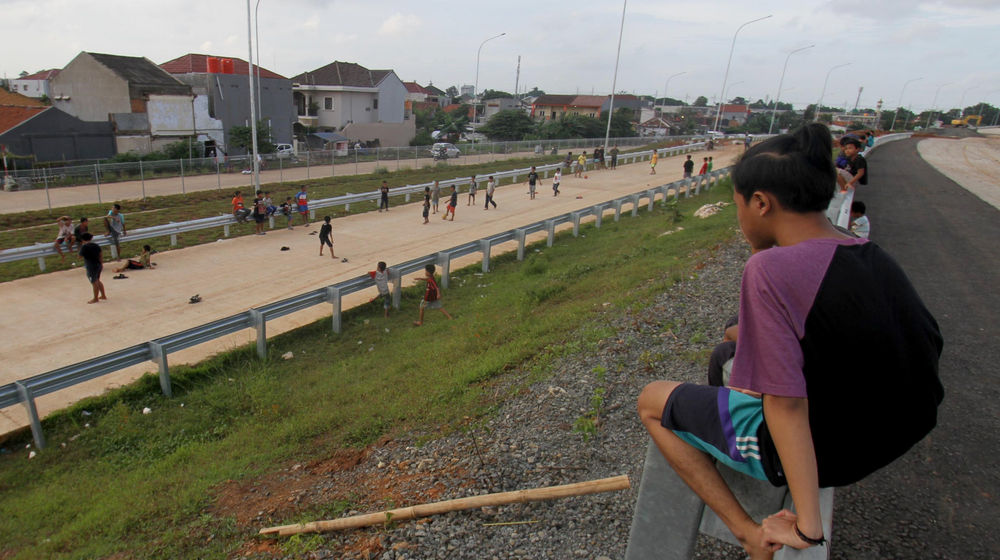 <p>Sejumlah anak bermain di ruas jalan tol Kunciran-Cengkareng, Jum’at, 12 Februari 2021. Foto: Panji Asmoro/TrenAsia</p>
