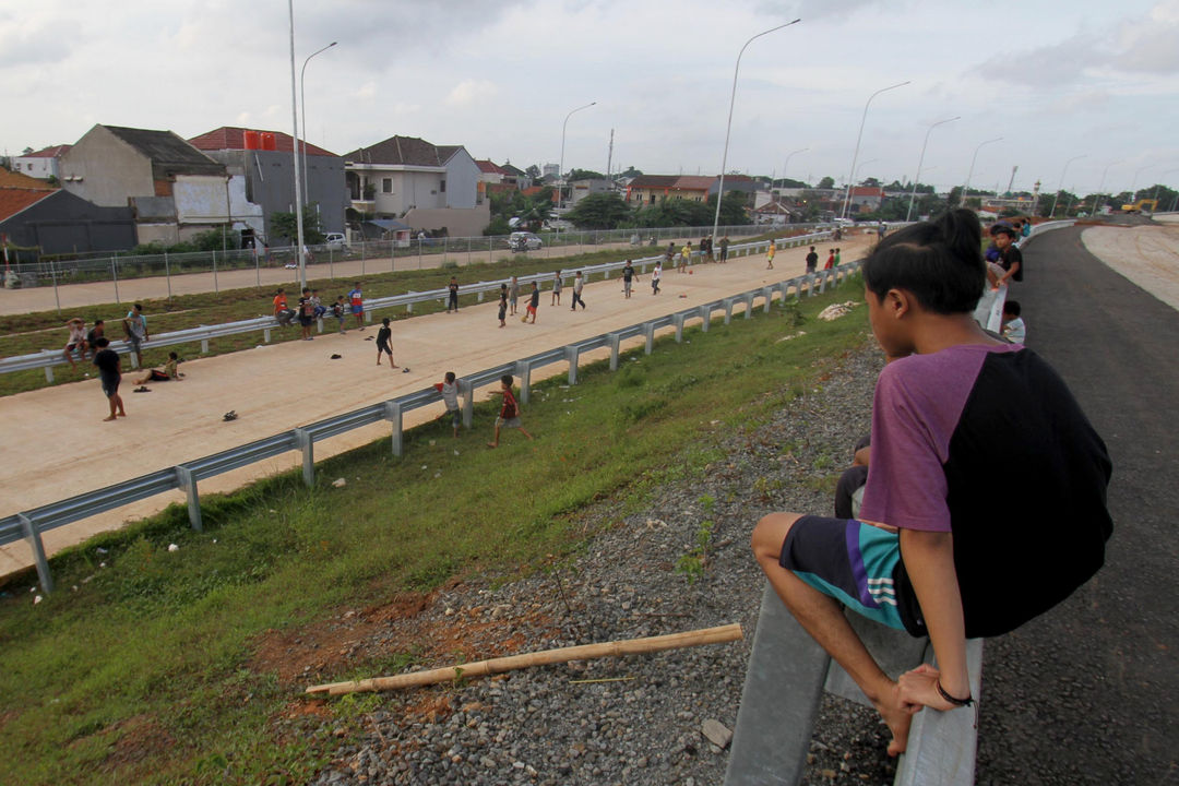 <p>Sejumlah anak bermain di ruas jalan tol Kunciran-Cengkareng, Jum&#8217;at, 12 Februari 2021. Foto: Panji Asmoro/TrenAsia</p>
