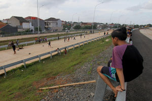 <p>Sejumlah anak bermain di ruas jalan tol Kunciran-Cengkareng, Jum’at, 12 Februari 2021. Foto: Panji Asmoro/TrenAsia</p>
