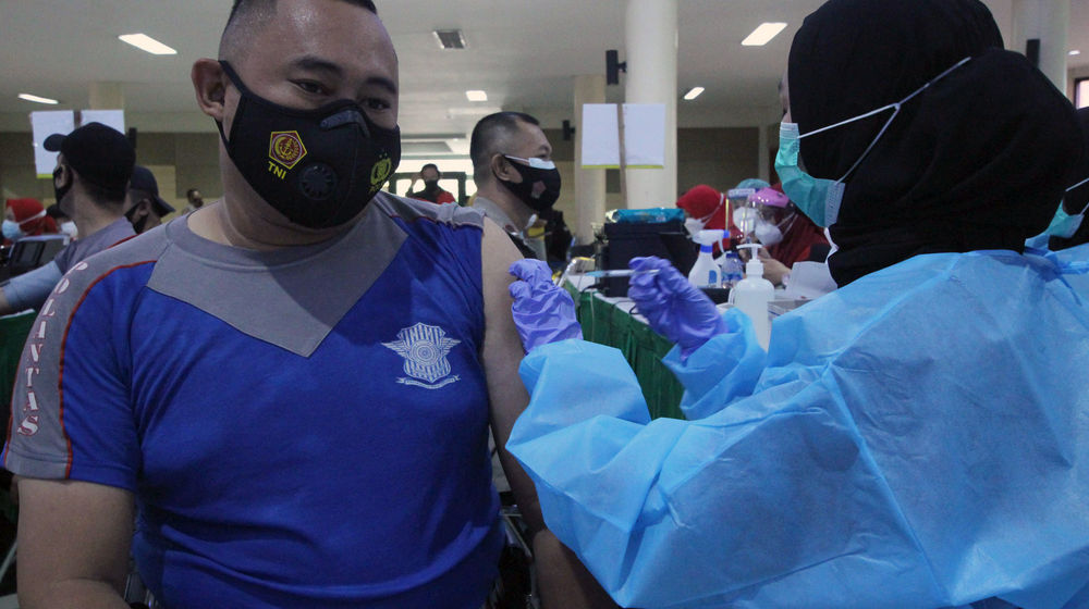 <p>Seorang anggota Polres Metro Kota Tangerang menjalani vaksinanasi di gedung pusat pemerintahan kota Tangerang, Jum’at, 26 Februari 2021. Foto: Panji Asmoro/TrenAsia</p>