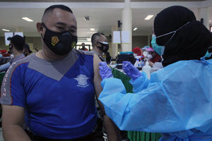 <p>Seorang anggota Polres Metro Kota Tangerang menjalani vaksinanasi di gedung pusat pemerintahan kota Tangerang, Jum’at, 26 Februari 2021. Foto: Panji Asmoro/TrenAsia</p>
