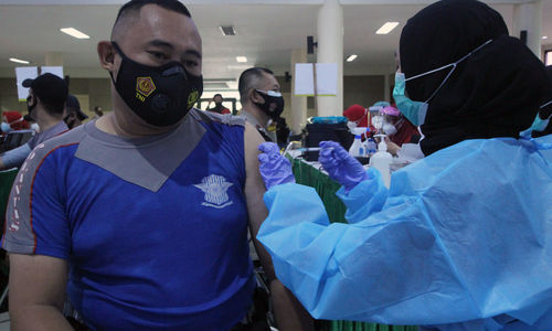 <p>Seorang anggota Polres Metro Kota Tangerang menjalani vaksinanasi di gedung pusat pemerintahan kota Tangerang, Jum’at, 26 Februari 2021. Foto: Panji Asmoro/TrenAsia</p>
