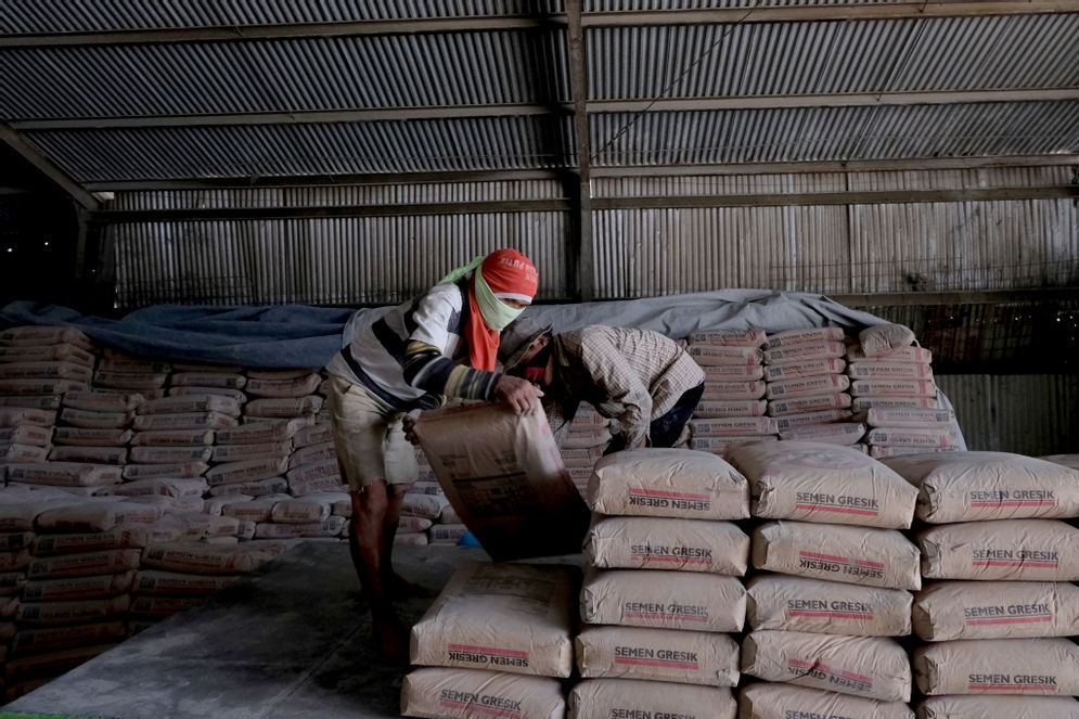 Pekerja melakukan bongkar muat semen di salah satu gudang distributor semen di Jalan Panjang Arteri Kelapa Dua Raya, Jakarta, Selasa, 1 Desember 2020. Foto: Ismail Pohan/TrenAsia