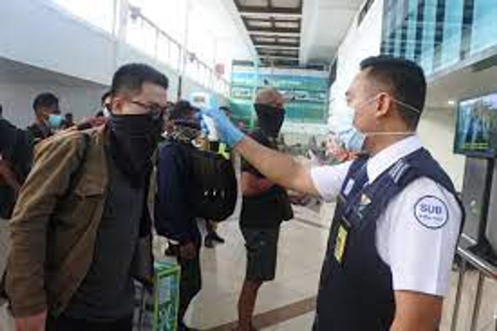Petugas Bandara Juanda memeriksa suhu tubu penumpang