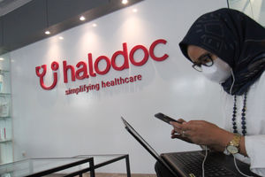 <p>Karyawati beraktivitas di dekat logo di kantor Halodoc kawasan Kuningan Jakarta. Foto : Panji Asmoro/TrenAsia</p>
