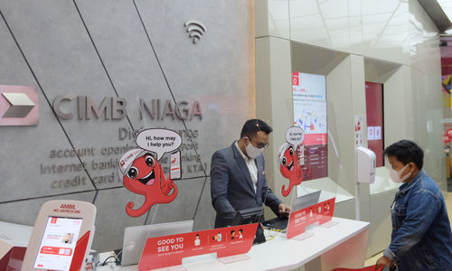 Karyawan melayani nasabah di gerai CIMB Niaga Ditigal Lounge, Mal Gandaria City, Jakarta, Kamis, 4 Maret 2021