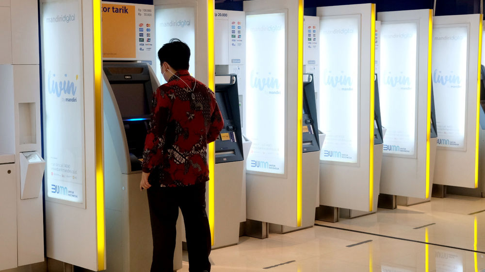 <p>Nasabah melakukan transaksi melalui mesin anjungan tunai mandiri (ATM) di kantor cabang Bank Mandiri, Plaza Mandiri, Jakarta, Senin, 22 Maret 2021. Foto: Ismail Pohan/TrenAsia</p>
