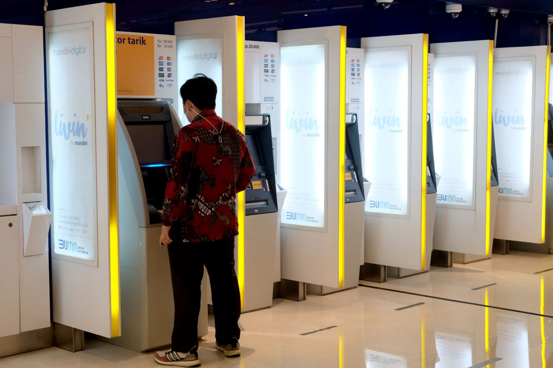 <p>Nasabah melakukan transaksi melalui mesin anjungan tunai mandiri (ATM) di kantor cabang Bank Mandiri, Plaza Mandiri, Jakarta, Senin, 22 Maret 2021. Foto: Ismail Pohan/TrenAsia</p>
