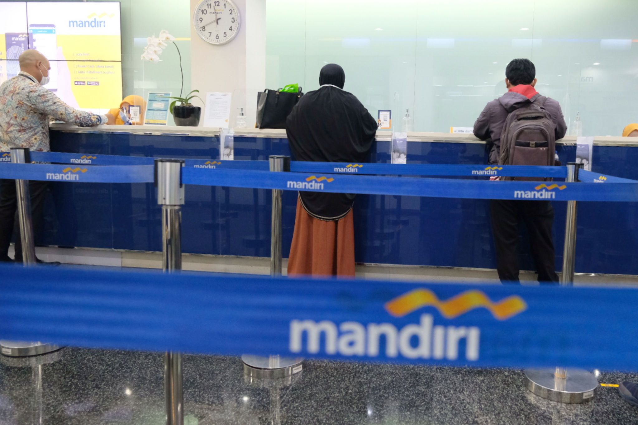 <p>Nasabah melakukan transaksi di counter kantor cabang Bank Mandiri, Plaza Mandiri, Jakarta, Senin, 22 Maret 2021. Foto: Ismail Pohan/TrenAsia</p>
