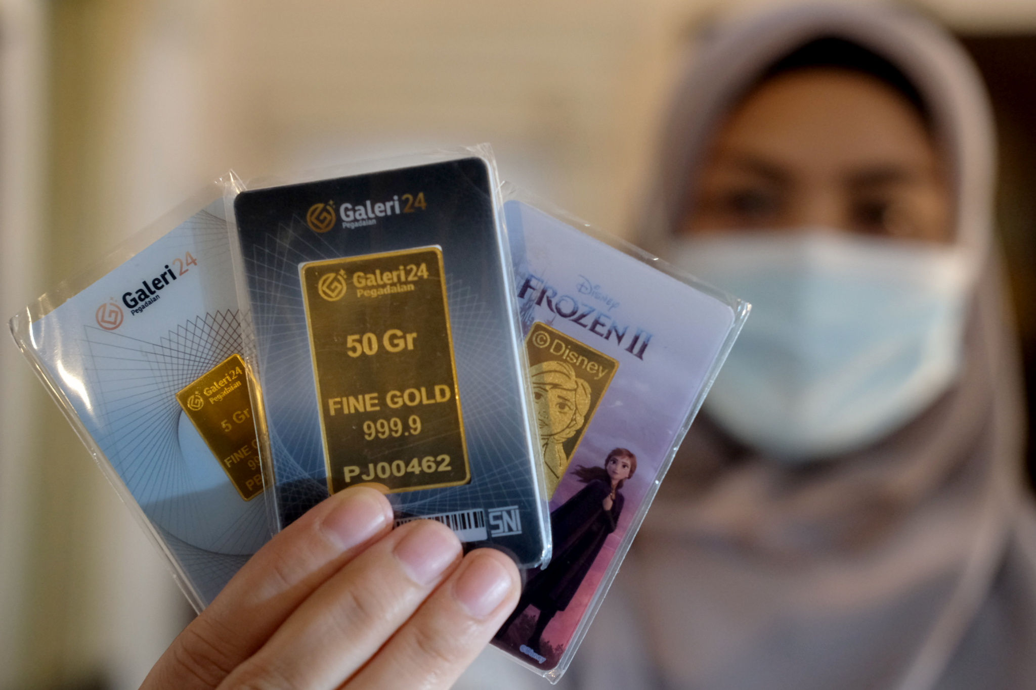 <p>Karyawati menunjukkan emas batangan di gerai Galeri 24 Pegadaian, Jakarta, Senin, 1 Maret 2021. Foto: Ismail Pohan/TrenAsia</p>
