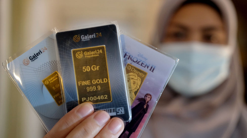 <p>Karyawati menunjukkan emas batangan di gerai Galeri 24 Pegadaian, Jakarta, Senin, 1 Maret 2021. Foto: Ismail Pohan/TrenAsia</p>
