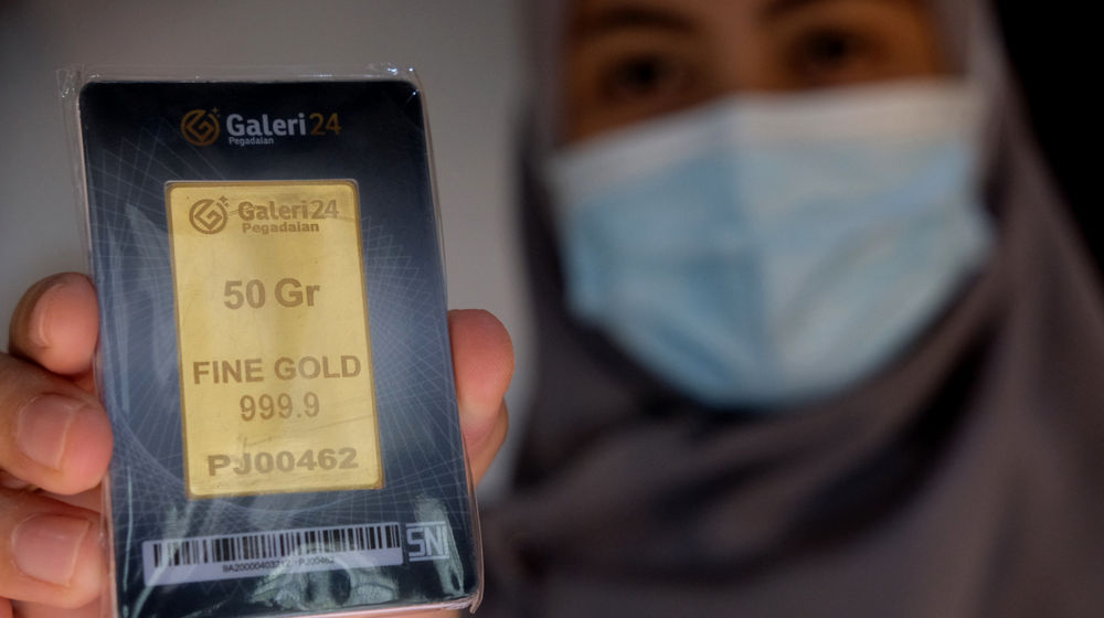 <p>Karyawati menunjukkan emas batangan di gerai Galeri 24 Pegadaian, Jakarta, Senin, 1 Maret 2021. Foto: Ismail Pohan/TrenAsia</p>

