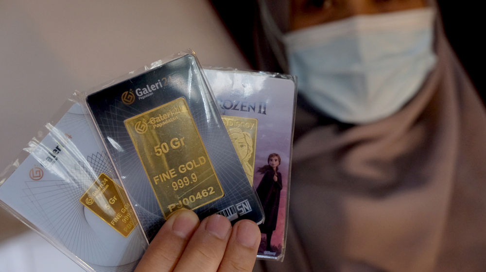 <p>Karyawati menunjukkan emas batangan di gerai Galeri 24 Pegadaian, Jakarta, Senin, 1 Maret 2021. Foto: Ismail Pohan/TrenAsia</p>
