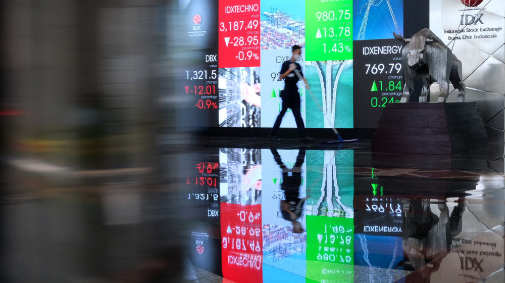 <p>Karyawan melintas dengan latar layar pergerakan indeks harga saham gabungan (IHSG) di Gedung Bursa Efek Indonesia (BEI), Jakarta, Senin, 1 Maret 2021. Foto: Ismail Pohan/TrenAsia</p>

