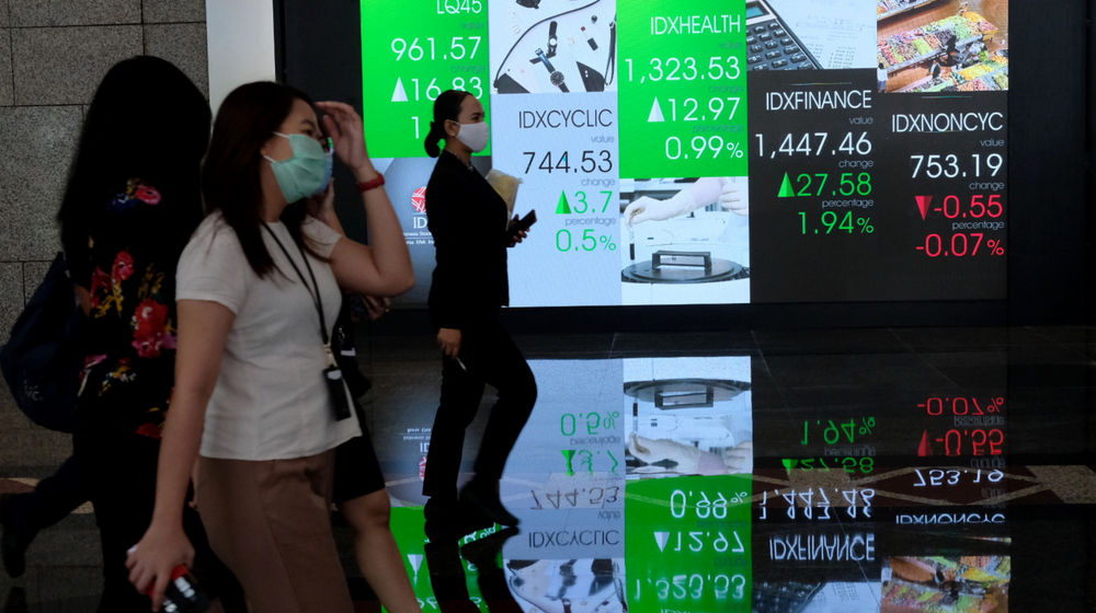 <p>Karyawan melintas dengan latar layar pergerakan indeks harga saham gabungan (IHSG) di Gedung Bursa Efek Indonesia (BEI), Jakarta, Senin, 1 Maret 2021. Foto: Ismail Pohan/TrenAsia</p>

