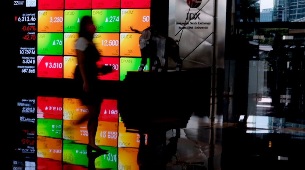 <p>Karyawan melintas dengam latar pergerkan indeks harga saham gabungan (IHSG) di gedung Bursa Efek Indonesia (BEI), Jakarta, Senin, 22 Maret 2021. Foto: Ismail Pohan/TrenAsia</p>