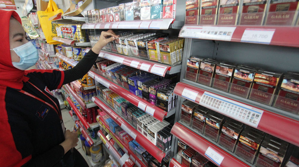 <p>Seorang karyawan tengah menata rokok dari berbagai jenis dan merk di sebuah etalase waralaba kawasan Cengkareng Jakarta Barat, Rabu 17 Maret 2021. Foto: Panji Asmoro/TrenAsia</p>
