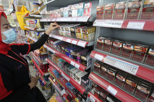 <p>Seorang karyawan tengah menata rokok dari berbagai jenis dan merk di sebuah etalase waralaba kawasan Cengkareng Jakarta Barat, Rabu 17 Maret 2021. Foto: Panji Asmoro/TrenAsia</p>
