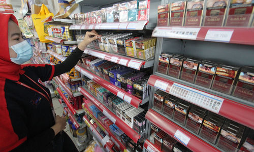 <p>Seorang karyawan tengah menata rokok dari berbagai jenis dan merk di sebuah etalase waralaba kawasan Cengkareng Jakarta Barat, Rabu 17 Maret 2021. Foto: Panji Asmoro/TrenAsia</p>
